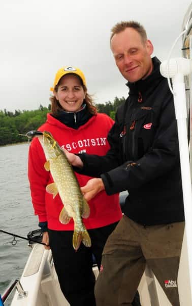 Lindström holds a pike after landing it.