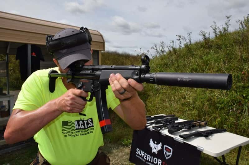 A shooter shoulders a D54P in 9x19mm paired with a select-fire trigger housing and mechanism. It's also sporting an Octane 9 suppressor.