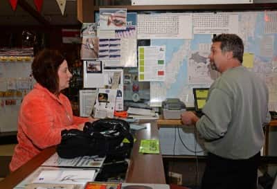 Michelle Kasten, Luxemburg, buys her family’s deer licenses from Lee Simonar, owner of Lee’s Sports.