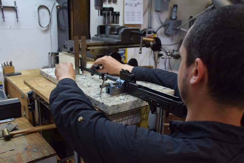 Chase checks the positions of the front sight base, gas block, and rear sight block on a gun.