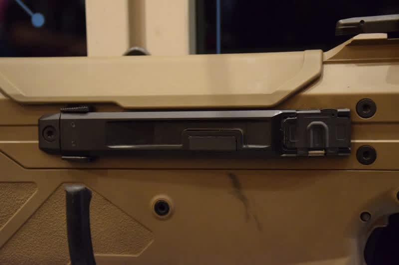 The ejection chute on the MDR. It can be quickly removed for swapping or malfunction clearing using the tabs at the rear.